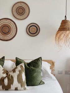 a bedroom with a bed with pillows and baskets on the wall at Harbour View House in St Ives