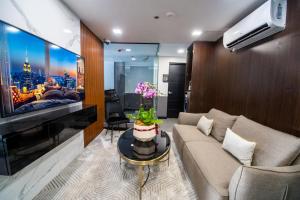 a living room with a couch and a tv at ASN Boutique Residence in Manila