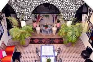 una casa per bambole con tavolo e piante in vaso di Riad Dar La Rose a Marrakech