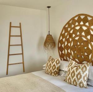 a bedroom with a bed with a wooden headboard and pillows at Harbour View House in St Ives