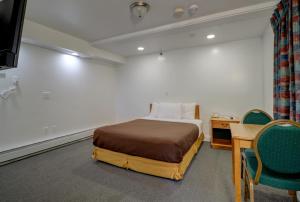 1 dormitorio con 1 cama, escritorio y sillas en Classic Inn, en Saco