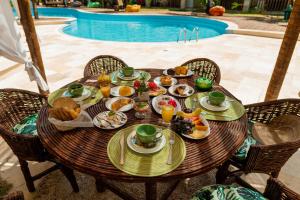 una mesa con platos de comida junto a una piscina en Camozen Resort & Spa, en Camocim