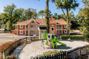 a playground in front of a house at Résidence Pierre & Vacances Les Dunes du Médoc in Soulac-sur-Mer