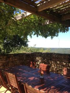 a wooden table and chairs on a patio at Le Refuge aux étoiles in Saint-Antonin