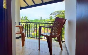 a chair sitting on a balcony with a view at Sea & Greens Apartments in Unawatuna