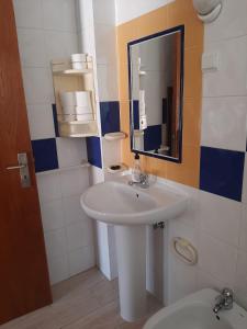 a bathroom with a sink and a mirror and a toilet at Casa Azul in Odeceixe