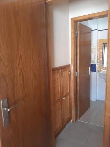 a room with a wooden door and a bathroom at Casa Azul in Odeceixe