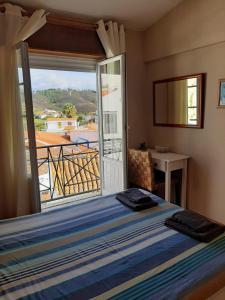 1 dormitorio con 1 cama y vistas a un balcón en Casa Azul, en Odeceixe