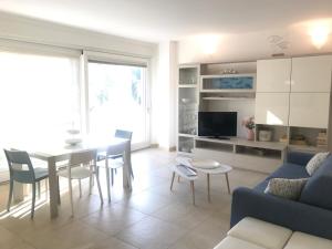 a living room with a table and a blue couch at Appartamento Rosa Residenza Prealba in Levanto