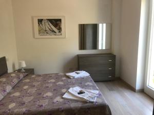 a bedroom with a bed with a dresser and a mirror at Appartamento Rosa Residenza Prealba in Levanto +1 photo