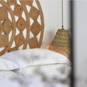 a bed with a head board and aendant light at Harbour View House in St Ives