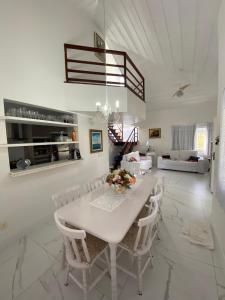 Casa com 4 quartos e 3 suítes no condomínio ferradura. في بوزيوس: غرفة طعام بيضاء مع طاولة بيضاء وكراسي