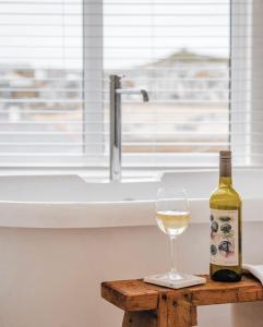 uma garrafa de vinho e um copo sobre uma mesa em Harbour View House em St Ives