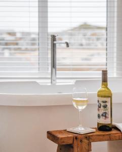a bottle of wine and a glass on a table at Harbour View House in St Ives