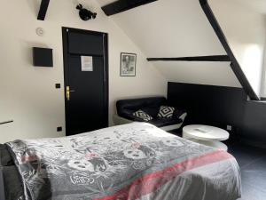 una camera con un letto e una sedia di Les Crinieres En Brie a Saint-Ouen-en-Brie