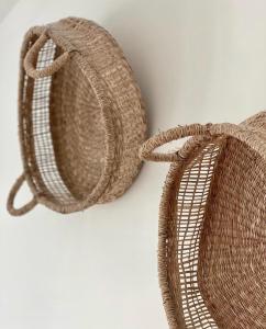 two wicker baskets sitting on a white wall at Harbour View House in St Ives