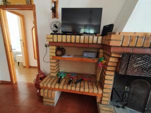 sala de estar con TV y chimenea en La Casa di Anna nel Parco della Majella Abruzzo Rapino CH, en Rapino