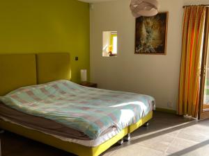 1 dormitorio con 1 cama en una habitación con paredes verdes en Les Crinieres En Brie, en Saint-Ouen-en-Brie