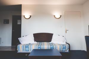 a hotel room with a bed and a table at Terres de France - Appart'Hôtel La Roche-Posay in La Roche-Posay