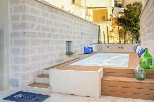 wanna z hydromasażem na patio z ceglaną ścianą w obiekcie Palazzo Vico Bianco Raro Villas Homes Collection w mieście Ostuni