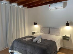 Pousada Cozy House في إتايبافا: غرفة نوم عليها سرير وفوط