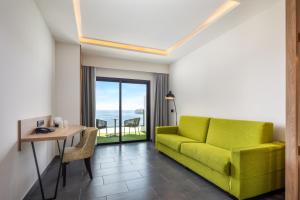 a living room with a green couch and a table at Occidental Roca Negra - Adults Only in Agaete