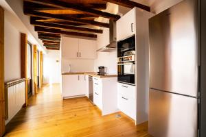 eine Küche mit weißen Schränken und einem Holzboden in der Unterkunft Smartr Madrid Gran Via Apartments in Madrid