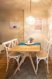 リバデセリャにあるI&I Apartamentのダイニングルーム(椅子とテーブル、シャンデリア付)