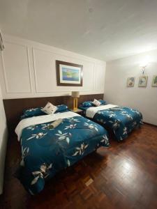 two beds in a hotel room with blue sheets at D'Sofiya Homestay A Famosa Melaka in Melaka
