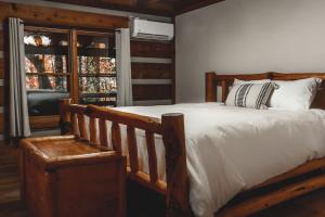 ein Schlafzimmer mit einem Holzbett und einem Fenster in der Unterkunft Pine Crest Cabin at 36 North - Hot Tub in Purlear