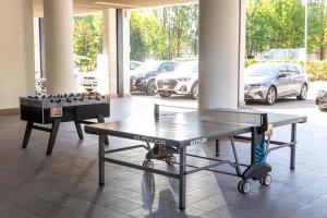 un tavolo da ping pong e una scacchiera in una stanza di Ramada Plaza Milano a Milano