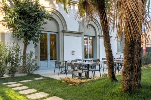 un patio avec des tables et des chaises et un palmier dans l'établissement Hotel Ariele, à Florence