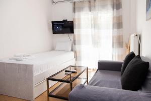 a small living room with a bed and a couch at Cozy apartment near Stavros Niarchos Park in Athens