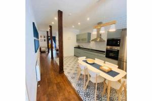 cocina y comedor con mesa y sillas en Lavaderu Apartamento, en Gijón