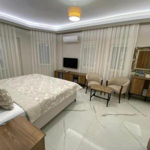 sypialnia z łóżkiem, biurkiem i telewizorem w obiekcie Hasanbey Apart Otel w mieście Belek