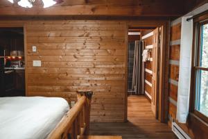 ein Schlafzimmer in einem Blockhaus mit einem Bett in der Unterkunft Wolf Creek Cabin at 36 North - Hot Tub in Purlear