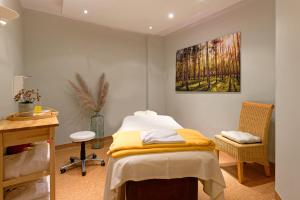 a hospital room with a bed and a painting on the wall at Hotel Sellhorn, Ringhotel Hanstedt in Hanstedt