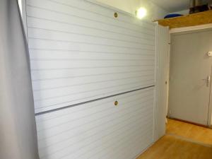 a white garage wall with a door in a room at Boost Your Immo Barèges Ayré PM48 in Barèges