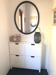 a white dresser with a mirror on top of it at Haus Anna in Rauma