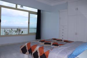a bedroom with a bed with a view of the ocean at Nour 1 in Alexandria