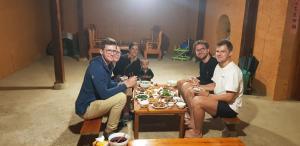 a group of people sitting around a table eating food at Diễn homestay in Quang Ba