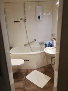 a bathroom with a tub and a toilet and a sink at Ferienhaus Baden in Simmelsdorf