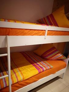 two bunk beds in a room with an orange blanket at Ferienhaus Baden in Simmelsdorf
