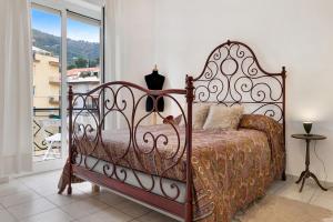 a bed in a bedroom with a large window at Casa Rosso Melograno in Alassio