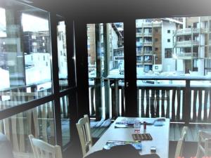 un tavolo con sedie in una camera con balcone di LA NORMA LES BALCONS DE LA Vanoise a La Norma