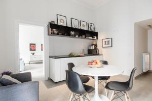 una cucina e un soggiorno con tavolo e sedie bianchi di Le Mummarelle Apartments a Napoli