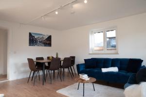 a living room with a blue couch and a table at SMS-Homes I AUSZEIT im BERGBLICKparadies in Sonthofen +17 photos