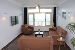 a living room with two couches and a window at Nour 1 in Alexandria