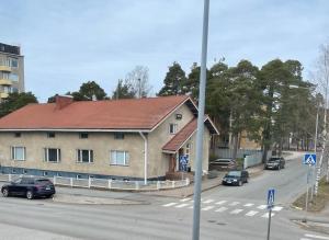 un bâtiment avec des voitures garées en face d'une rue dans l'établissement Haus Anna, à Rauma