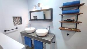 ein Badezimmer mit 2 Waschbecken, einem Spiegel und Handtüchern in der Unterkunft Hotel Tabasco in Playa Flamingo + 50 Fotos